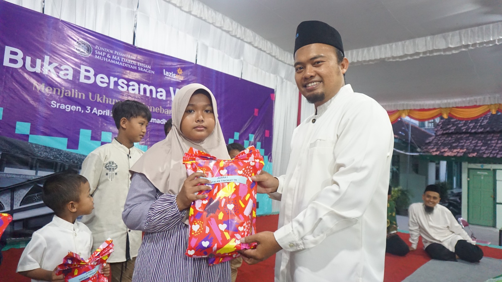Kepala SMP Dimsa Wibowo Juli Saputro serahkan bansos ke warga sekitar Ponpes Dimsa. (Ahmad Khairudin/Radar Solo)