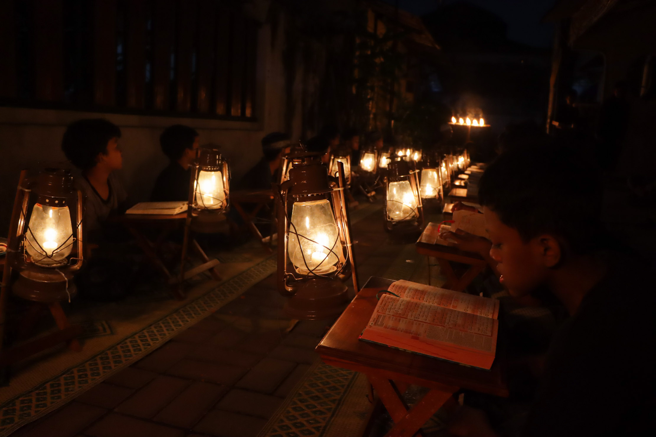 Anak-anak warga Kampung Prajurit Wirotamtomo, Kelurahan Baluwarti, Kecamatan Pasar Kliwon mengaji Alquran dengan lampu penerangan senthir, Rabu (3/4) malam. (M.Ihsan/Radar Solo)
