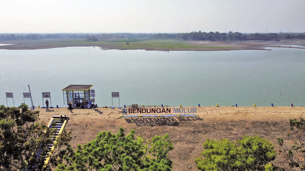 BERSEJARAH: Pemancing berjajar di tanggul, sebelah pintu air Waduk Mulur, Kecamatan Bendosari, belum lama ini.