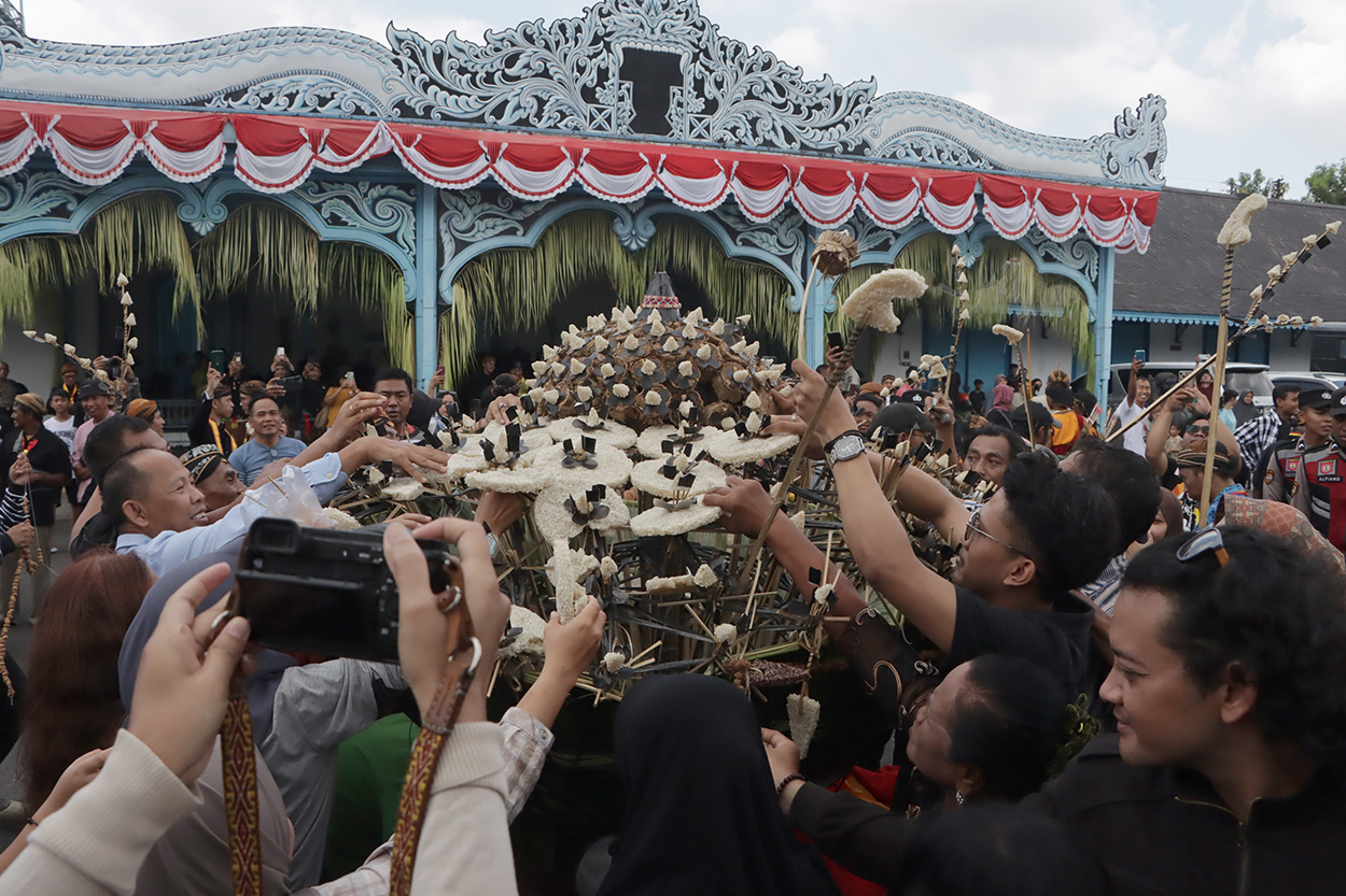 Warga berebut gunungan hasil bumi dan jajanan pasar dalam kegiatan Grebeg Pasa Keraton Kasunanan Surakarta Kamis (11/4/2024) pagi.