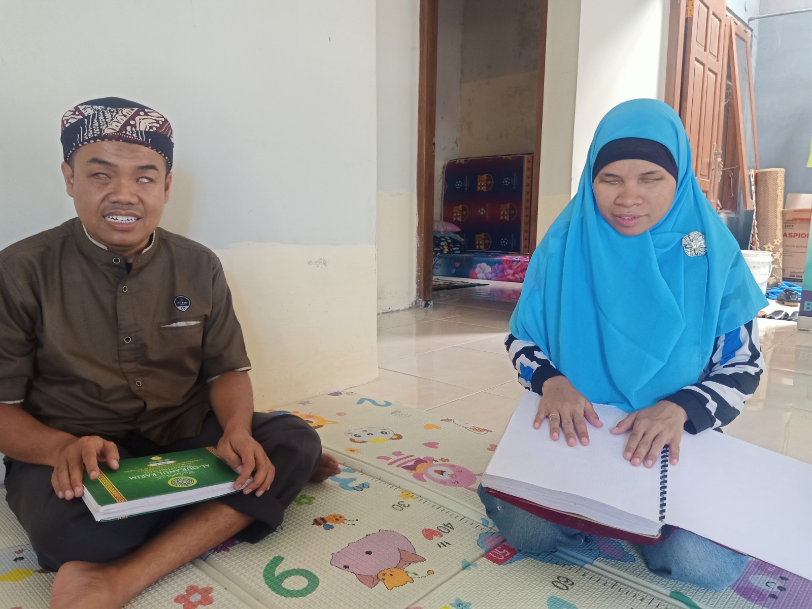 Pasutri Santo Setiawan-Diana Puspitasari membaca Alquran braile