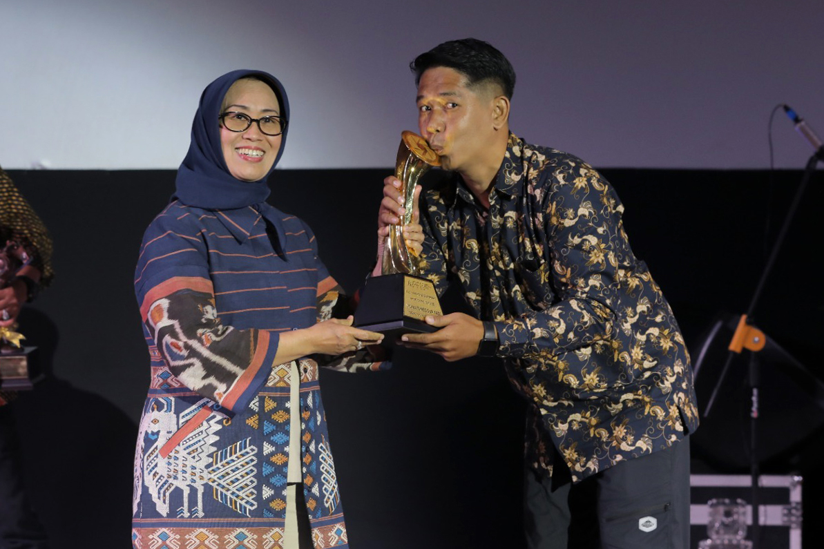 Ketua Dewan Pers, Ninik Rahayu menyerahkan trophy kepada Ketua PFI Solo, Yoma Times Suryadi yang berhasil meraih penghargaan Photo of The Year APFI dalam APFI 2024, Jumat (3/5/2024).