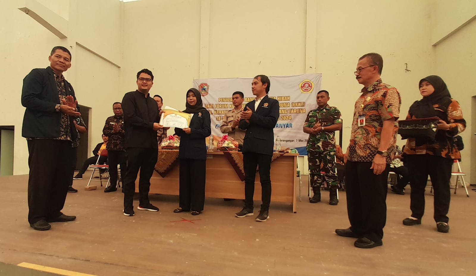Ketua FKKT Kabupaten Karanganyar Ilyas Akbar Almadhani menyerahkan dana hibah dari Dinsos Karanganyar ke karang taruna. (Rudi Hartono/Radar Solo)