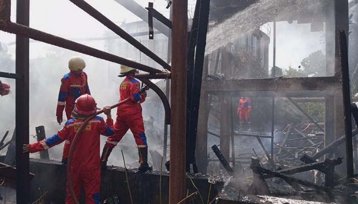 Petugas damkar dan relawan berupaya memadamkan api yang membakar gudang milik Pabrik Gula Tasikmadu, Karanganyar.