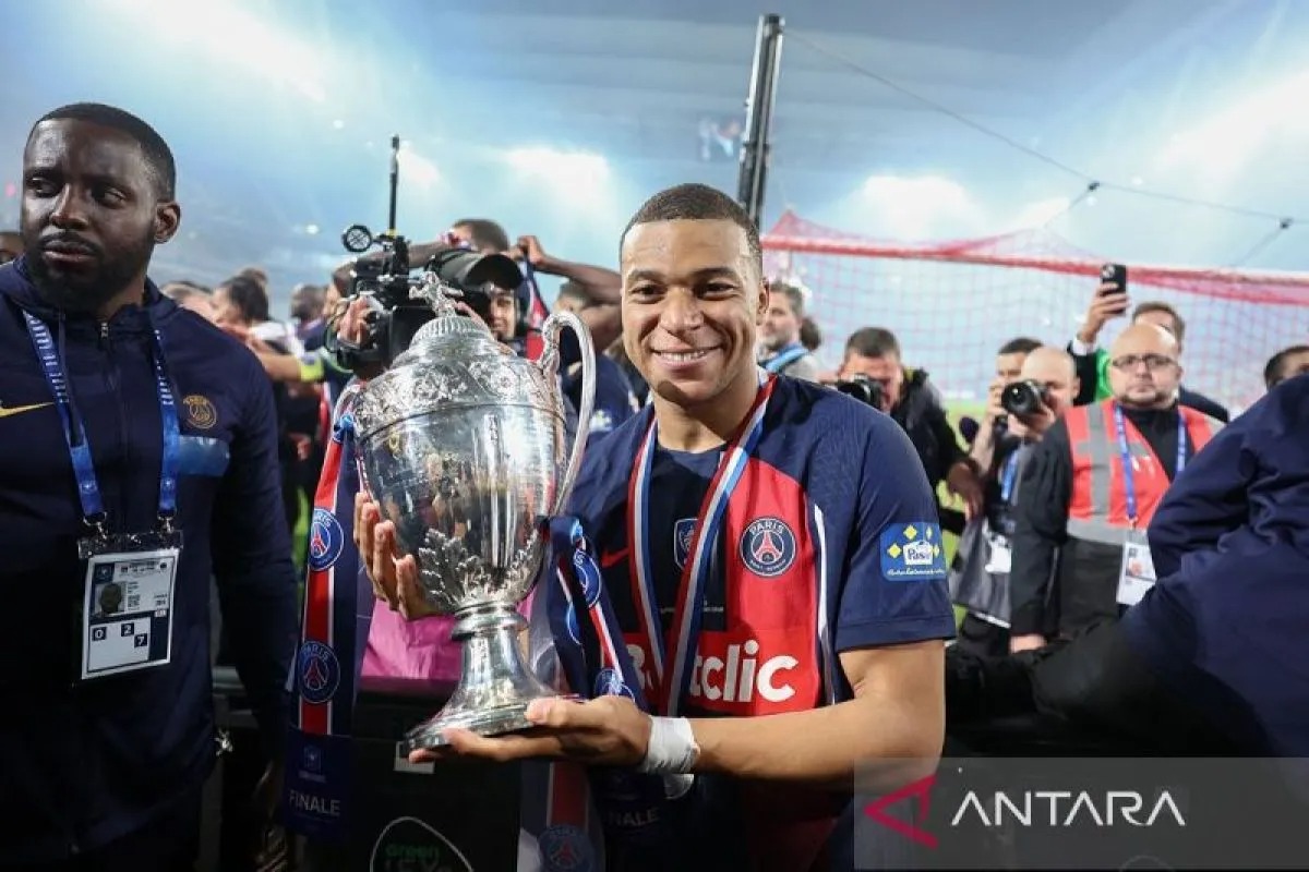 Penyerang Paris Saint-Germain, Kylian Mbappe menggenggam trofi Piala Prancis setelah memenangkan laga final atas Olympique Lyonnais dengan skor 2-1 di Stade Pierre-Mauroy Villeneuve-d