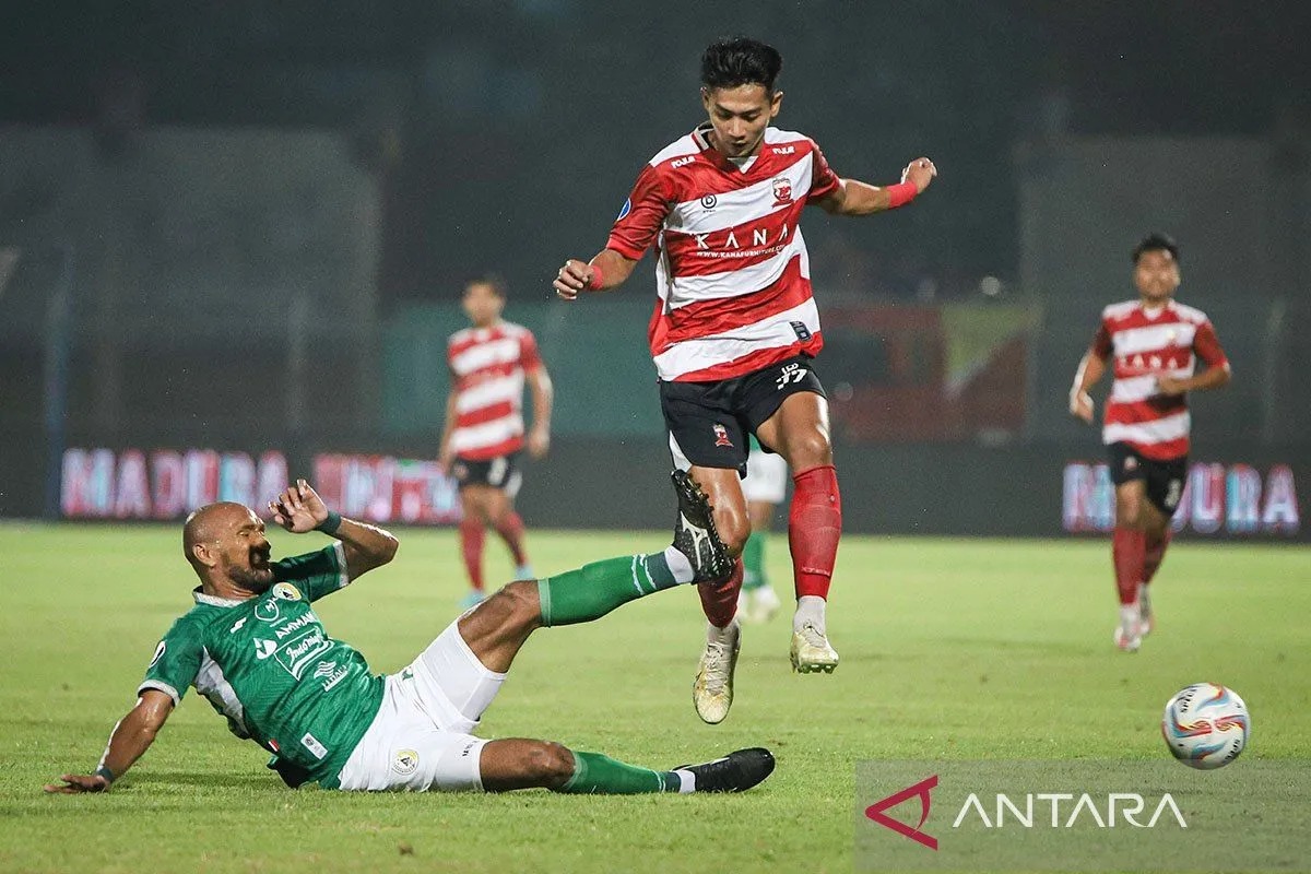 Pesepak bola Madura United Malik Risaldi (kanan) melewati hadangan pesepak bola PSS Sleman Leonard Tupamahu (kiri) pada laga BRI Liga 1 di Stadion Gelora Bangkalan, Timur, Jumat (29/3/2024).