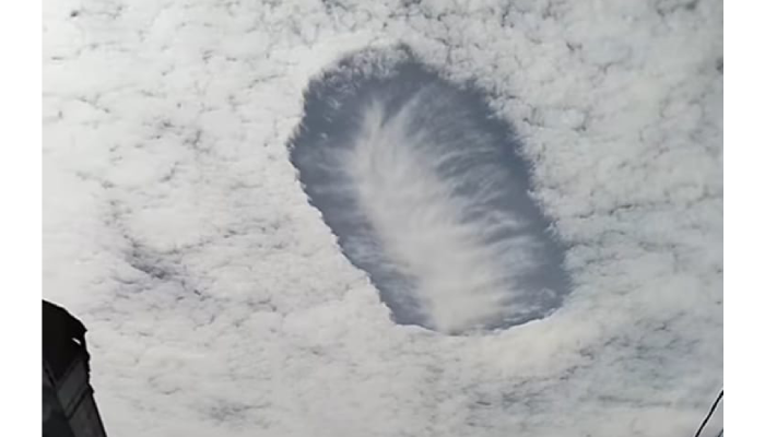 Fenomena awan berlubang yang terlihat di langit Jember.