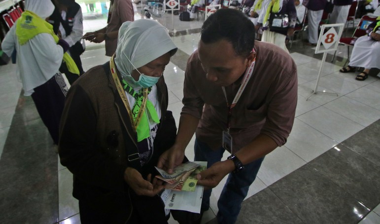 Salah seorang calon jemaah haji dari Embarkasi Solo menerima mata uang Arab Saudi sebagai biaya hidup selama di Tanah Suci. (Arief Budiman/Radar Solo)