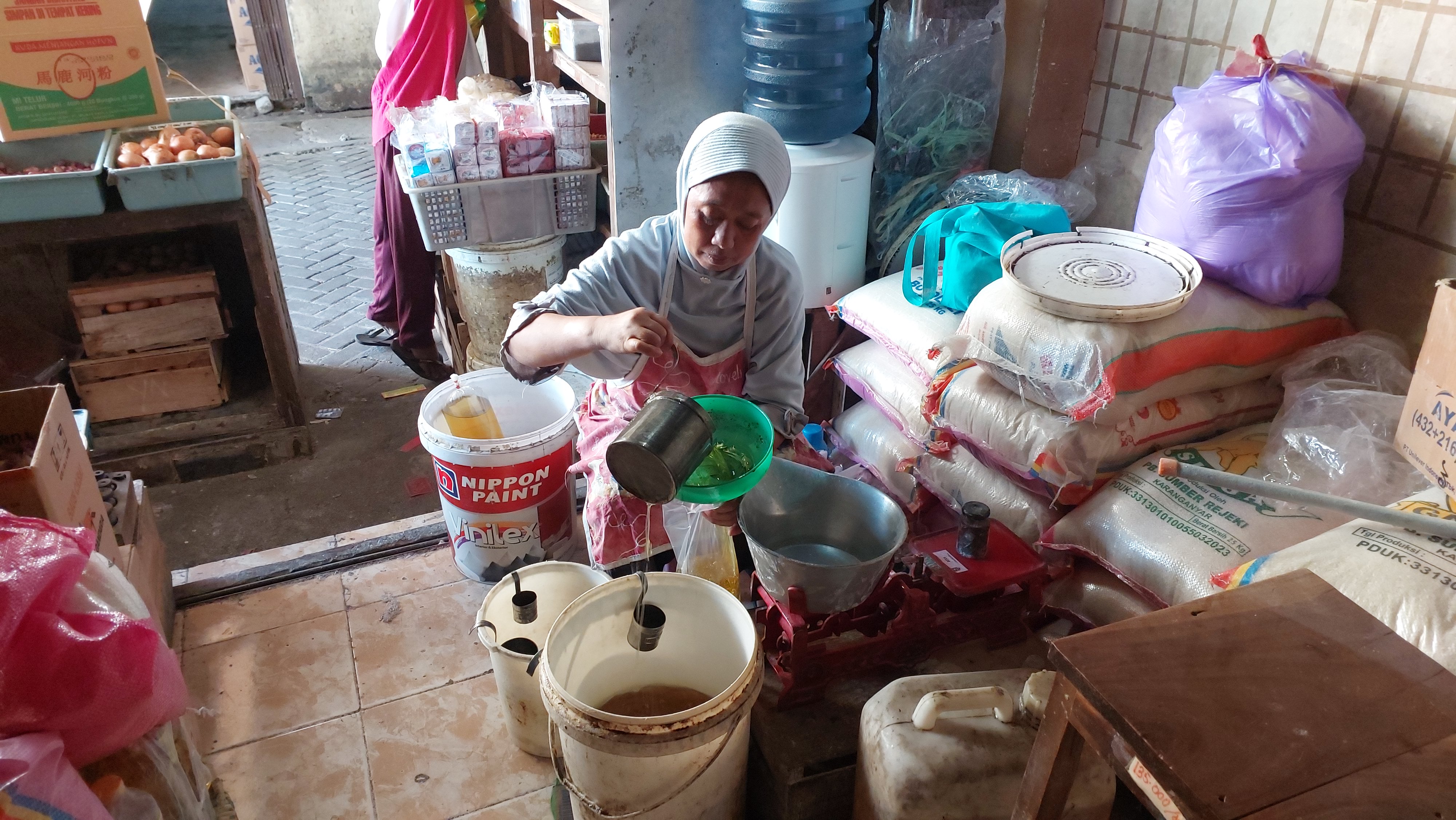 Pedagang di pasar tradisional Boyolali menakar minyak goreng curah, Kamis (13/6/2024).