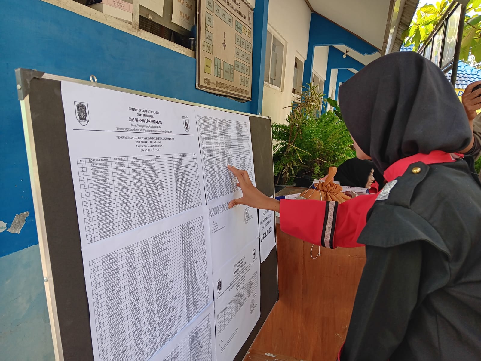 Calon siswa melihat daftar pengumuman PPDB online dan offline di SMPN 2 Prambanan, Klaten. (ANGGA PURENDA/RADAR SOLO)
