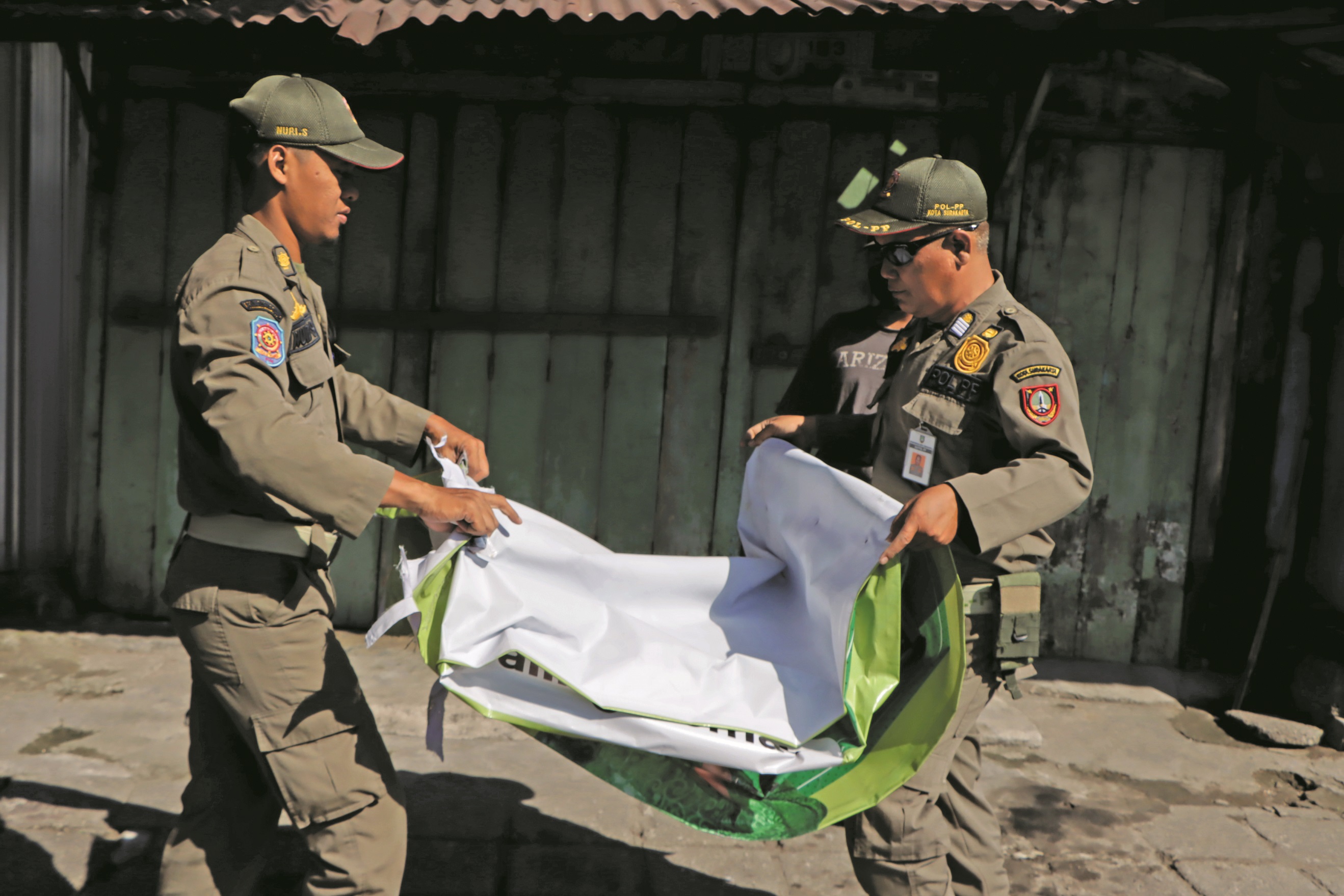 Satpol PP Kota Solo tertibkan spanduk liar iklan rokok. (Silvester Kurniawan/Radar Solo)
