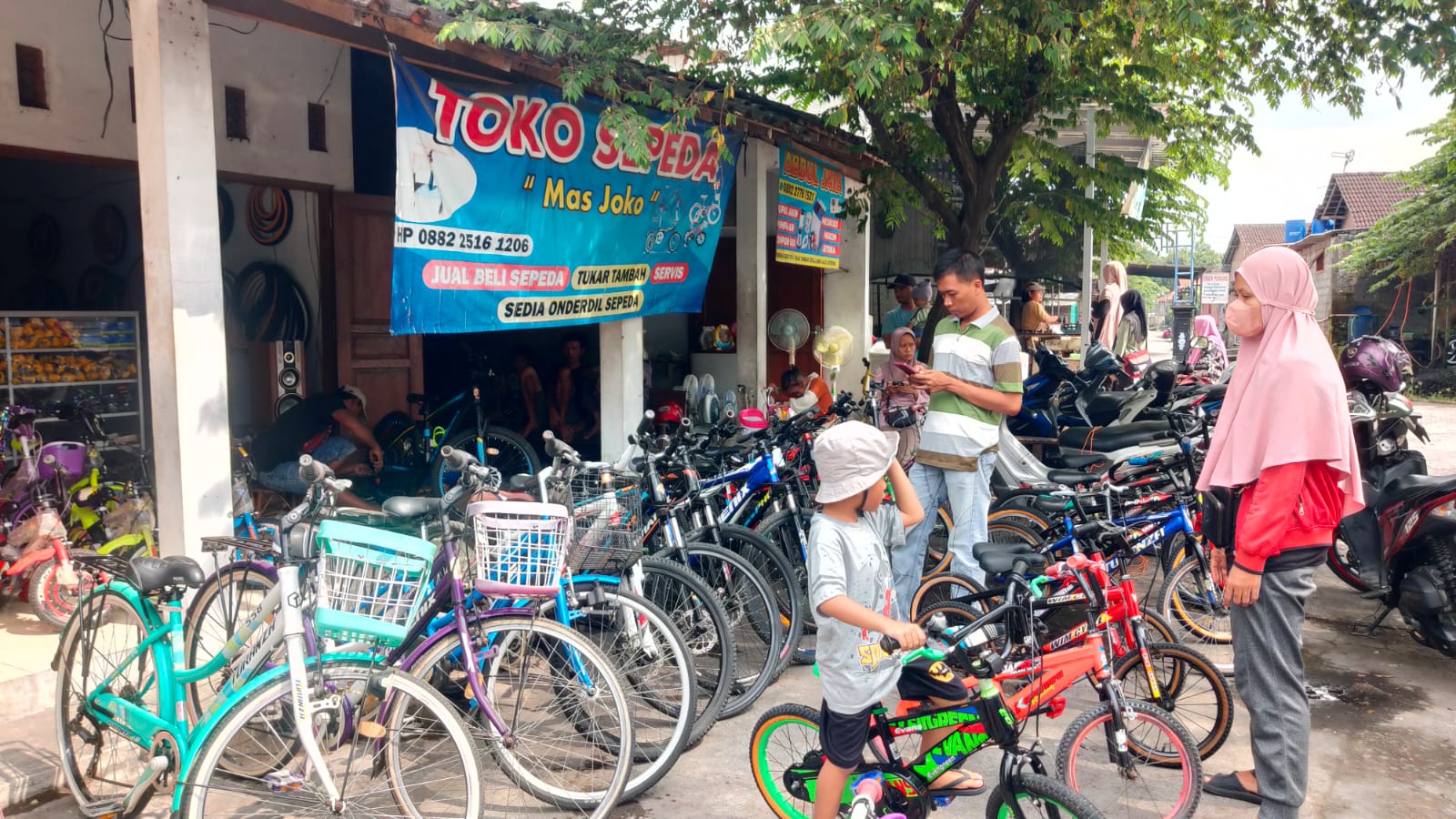Orang tua dan anak memilih sepeda di Pasar Pengging, Banyudono, Boyolali, Minggu (30/6/2024).