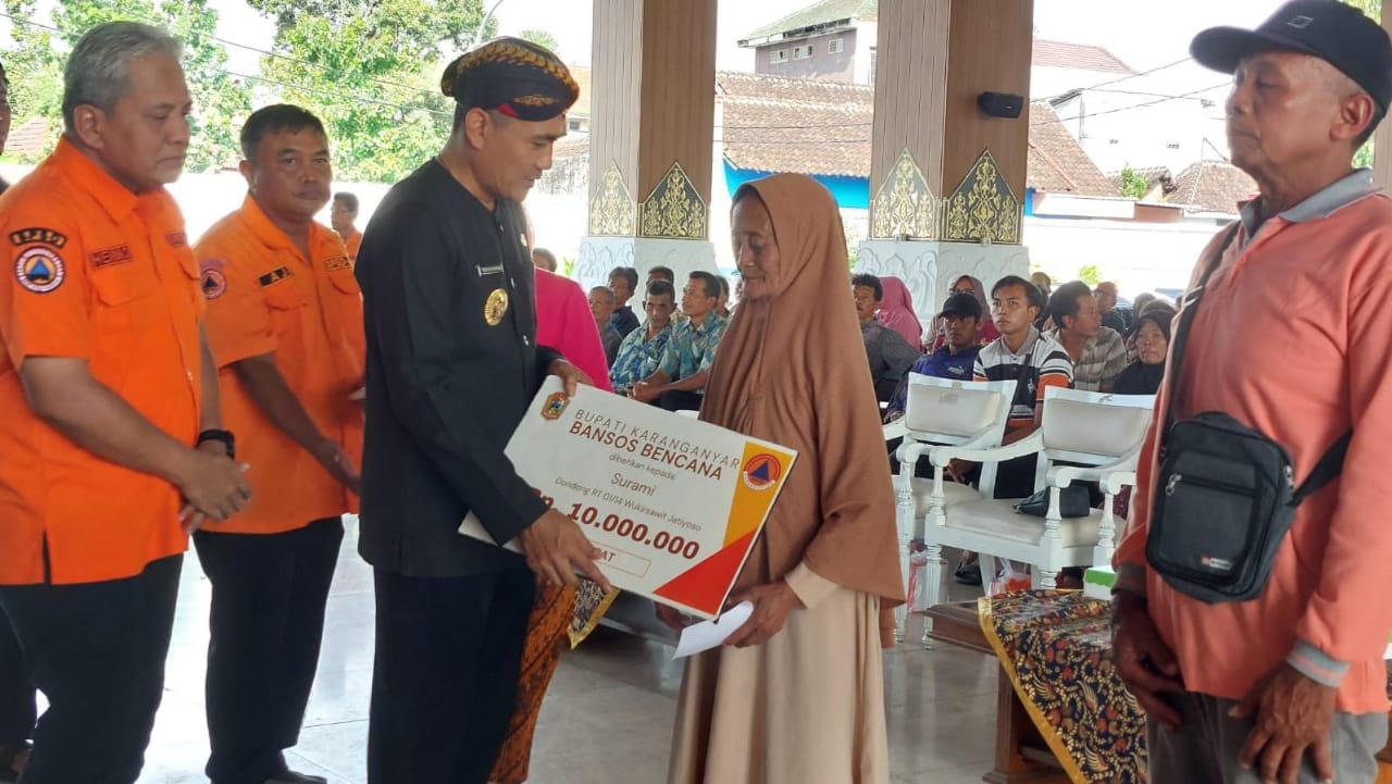 Pj Bupati Karanganyar Timotius Suryadi menyerahkan bantuan kepada korban bencana alam. (Rudi Hartono/Radar Solo)