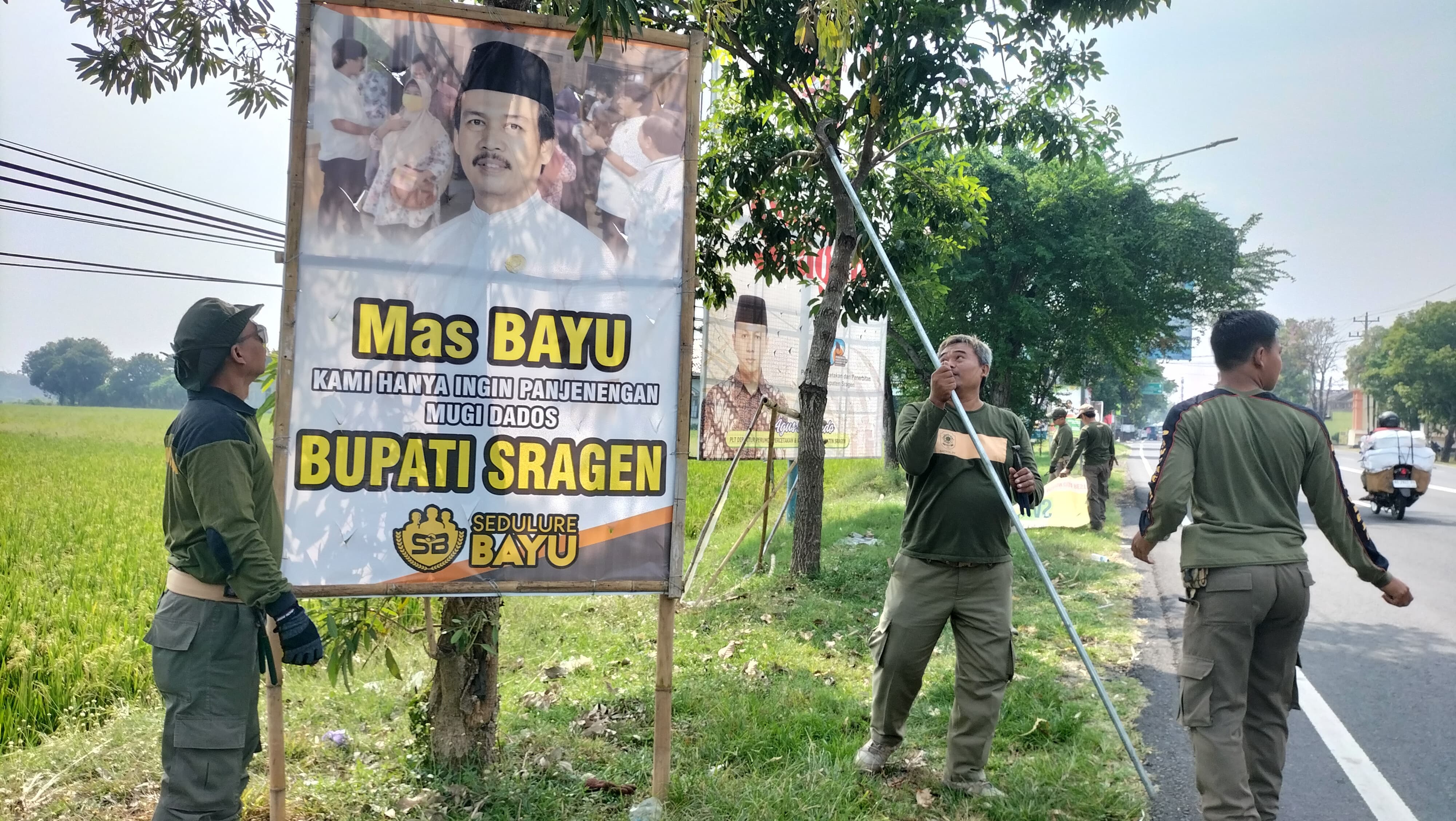 Satpol PP Sragen mencopot baliho bergambar bakal calon bupati. (Ahmad Khairudin/Radar Solo)