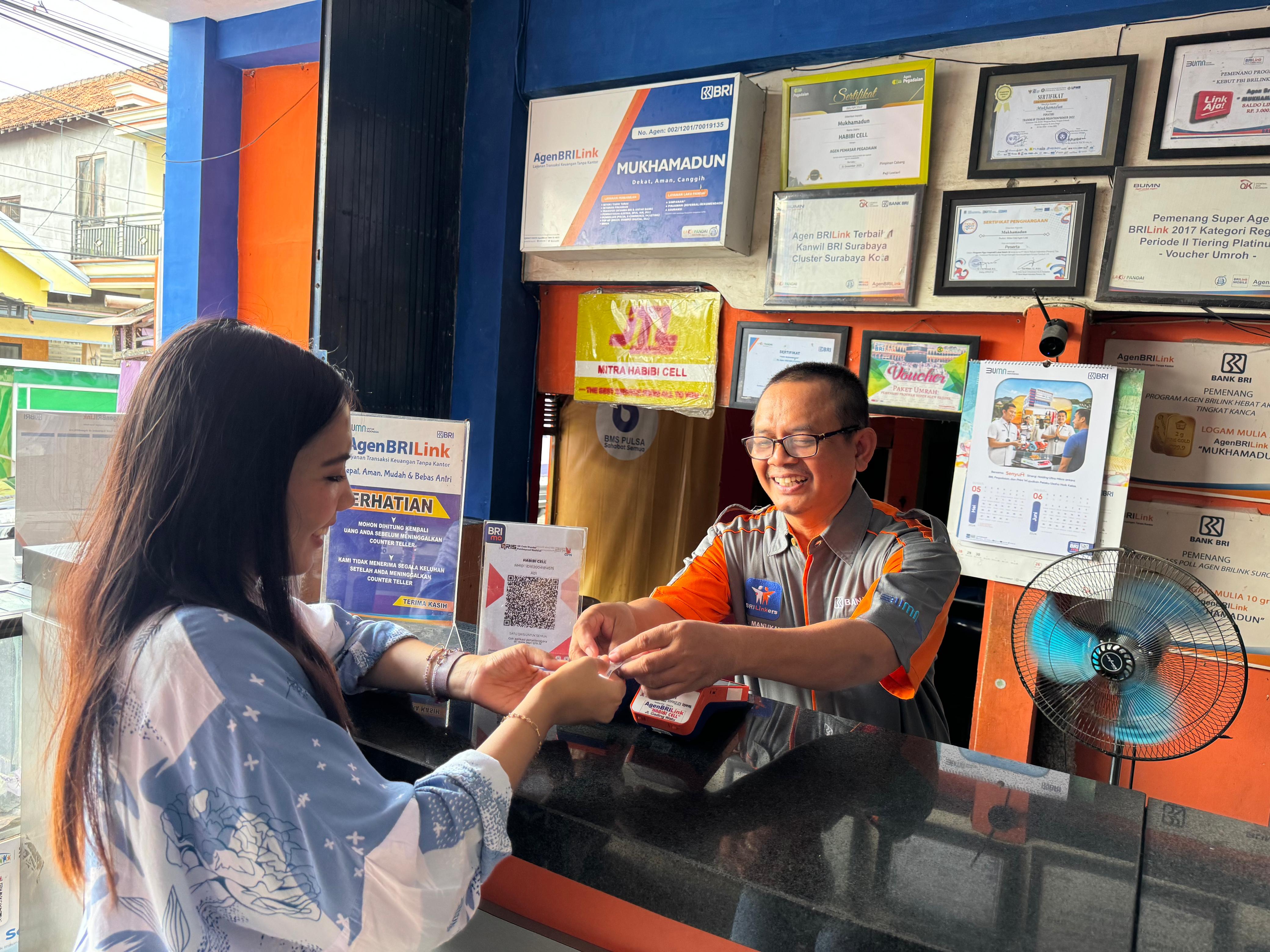 Mukhamadun melayani nasabah di AgenBRILink di Jalan Gading Watu, RT 01 RW 05, Kecamatan Menganti, Kabupaten Gresik, Jawa Timur.