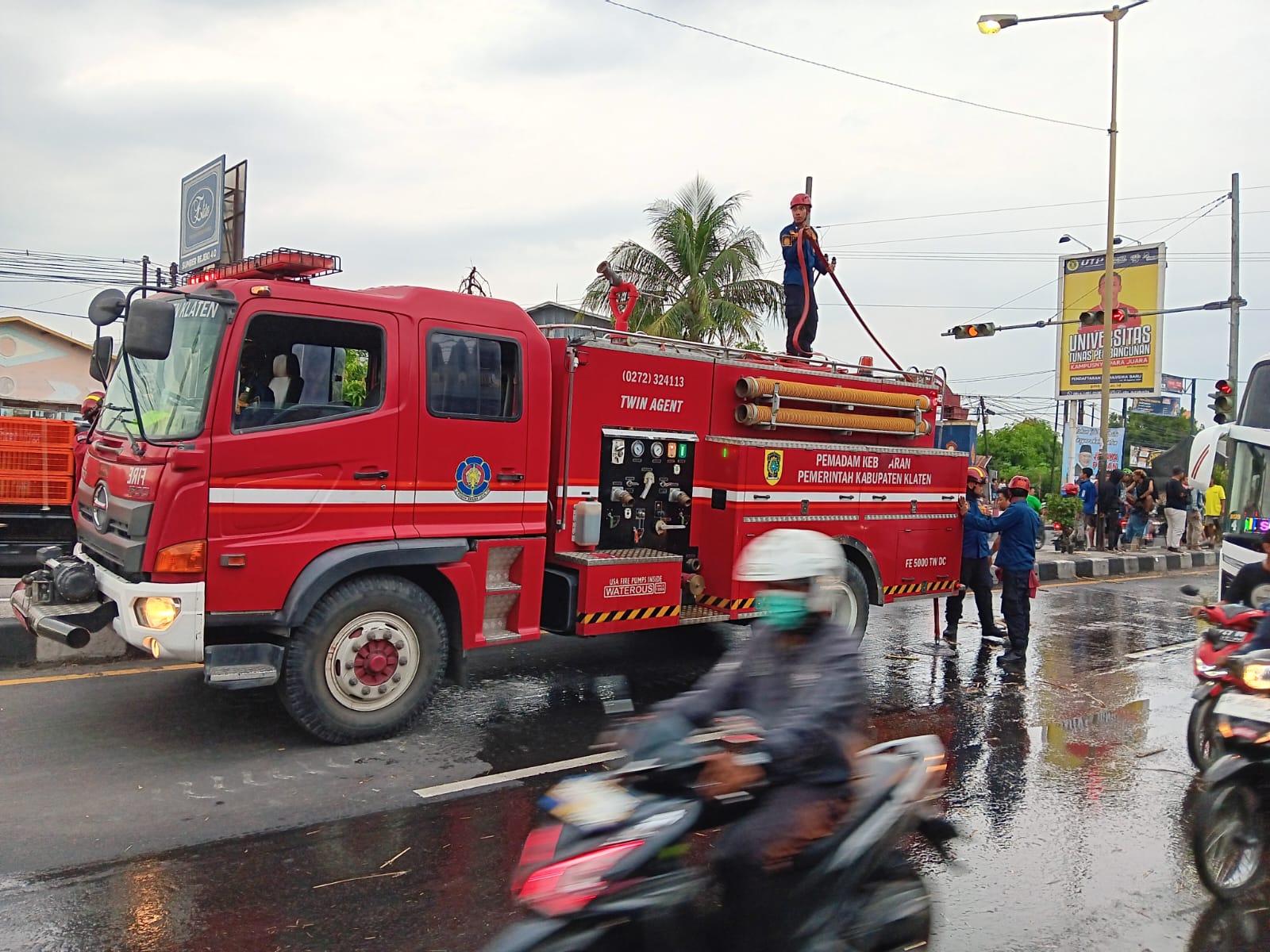 Tim damkar Klaten saat membersihkan jerami dari kecelakaan truk tebu di Jalan Solo-Jogja, Karangwuni, Klaten. (Angga Purenda/Radar Solo)