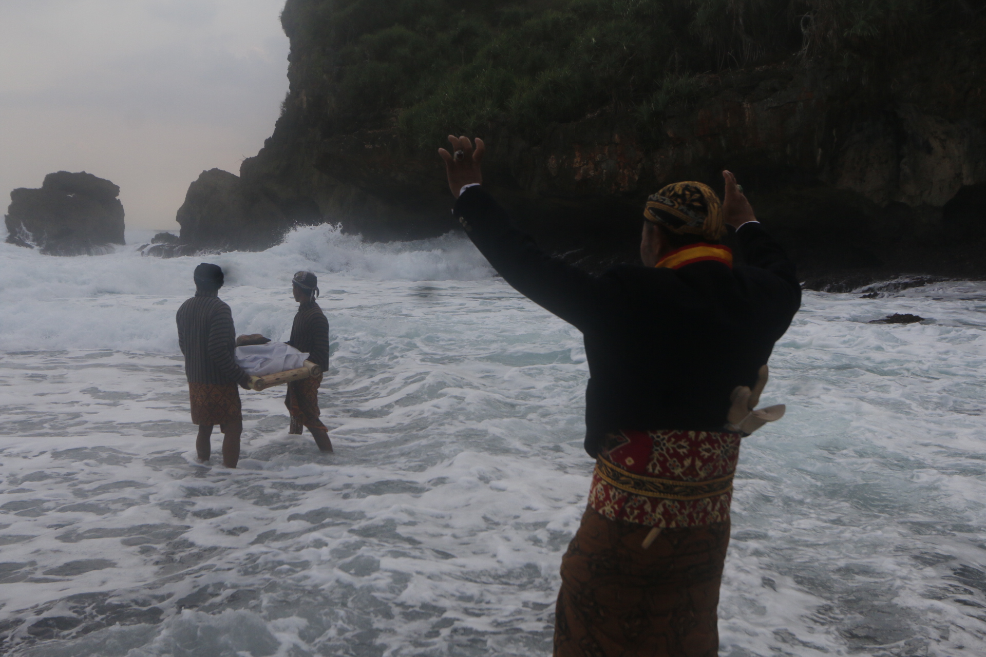 Peserta Labuhan Ageng melarung kepala sapi di Pantai Sembukan.