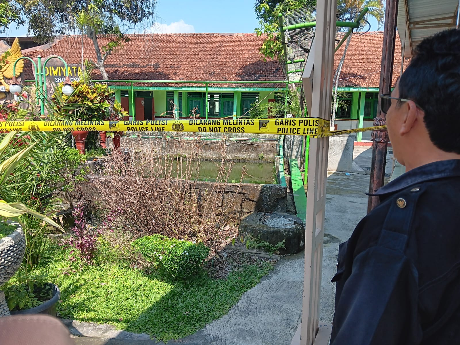 Kolam lokasi meninggalnya ketua OSIS SMAN 1 Cawas, Klaten dipasangi garis polisi. (Angga Purenda/Radar Solo)