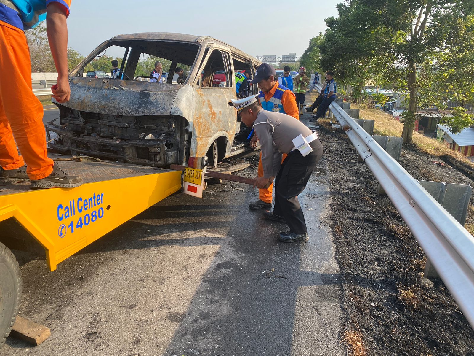 Petugas mengevakuasi minibus nopol B 1032 CVN terbakar di jalan Tol Semarang-Solo, tepatnya KM 496+800 Dusun/Desa Ngresep, Kecamatan Ngemplak, Boyolali, Selasa (23/7/2024).