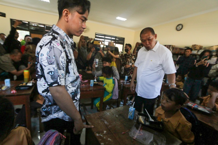 Wapres terpilih Gibran Rakabuming Raka didampingi Walikota Solo Teguh Prakoso tinjau uji coba makan bergizi gratis di SDN Tugu 120 Jebres, Jumat (26/7/2024).