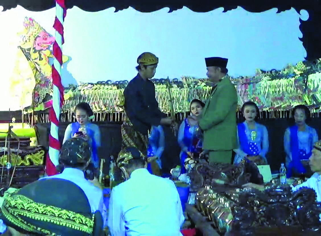 Penyerahan wayang kulit dari ketua panitia Merti Dukuh Sodong ke dalang Ki Catur Nugroho.