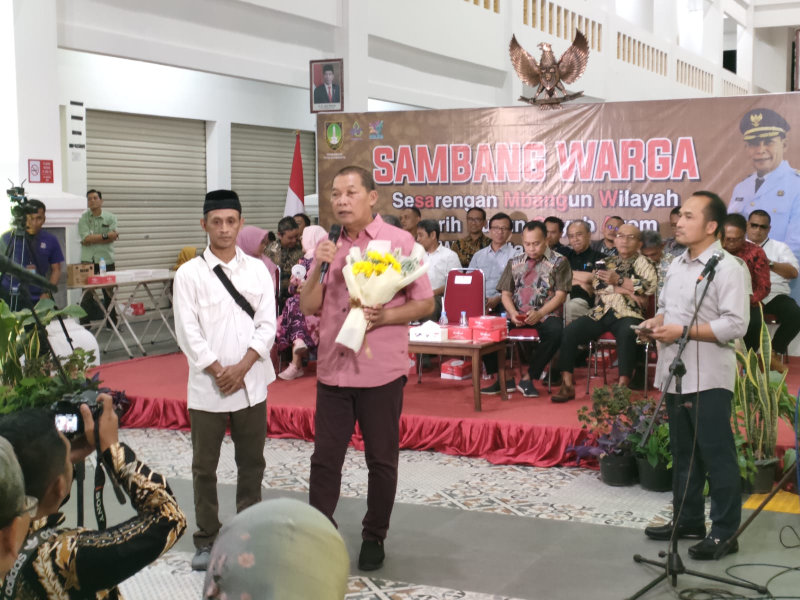 Wali Kota Surakarta Teguh Prakosa saat dihadiahi buket kembang warna kuning oleh warga dalam giat Sambang Warga di Pasar Jongke, Senin (26/8/2024).