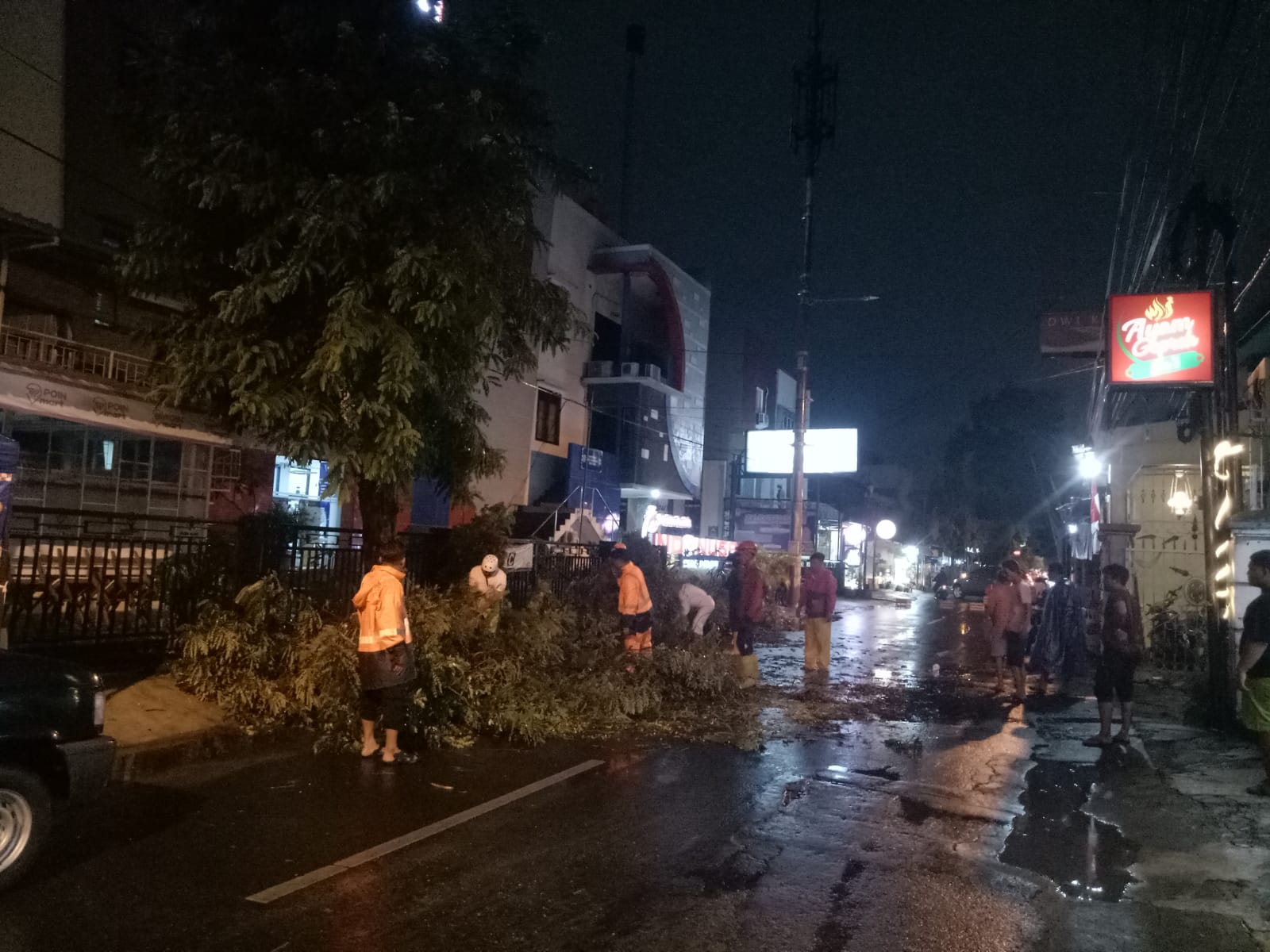 Petugas BPBD Kota Solo mengevakuasi pohon tumbang di depan kampus Indonusa Surakarta Jalan Jalan K.H. Samanhudi, Kelurahan Bumi, Kecamatan Laweyan, Kota Solo, Minggu (8/9/2024) malam.