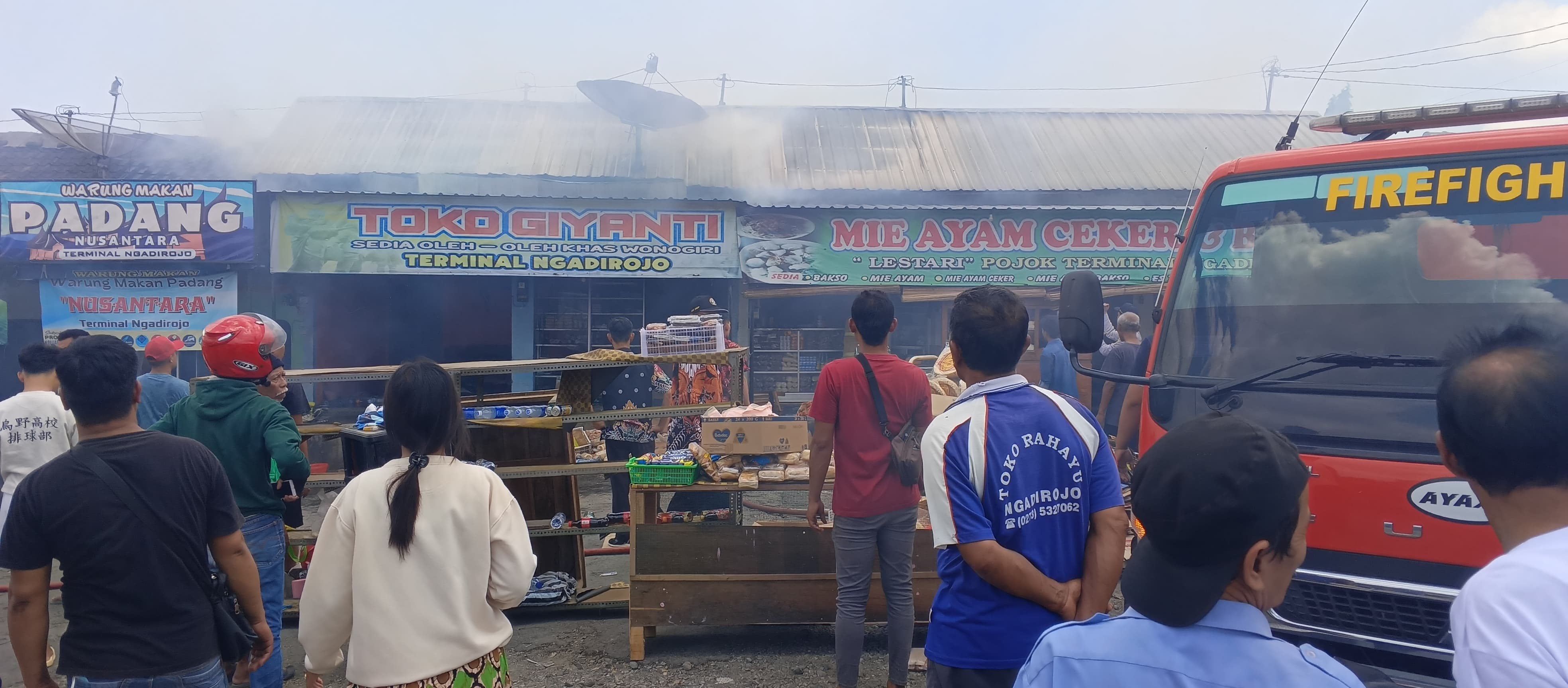 Warga dan pedagang mengamati petugas Damkar Wonogiri yang padamkan kebakaran kios di Terminal Ngadirojo, Wonogiri, Kamis (12/9/2024).