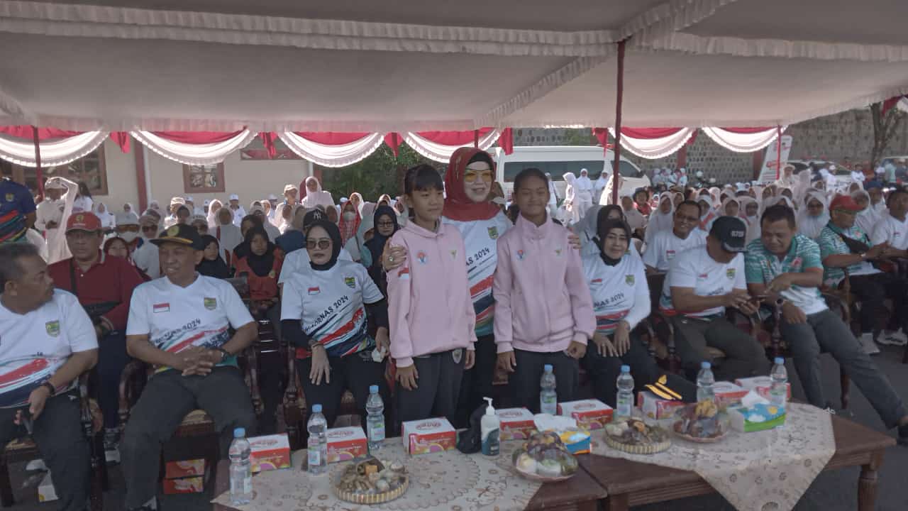 Bupati Sukoharjo Etik Suryani memeluk Civara Arta Pramininditya dan Delisa Cahaya Istigfara saat peringatan Haornas di Stadion Gelora Merdeka Jombor (13/9).