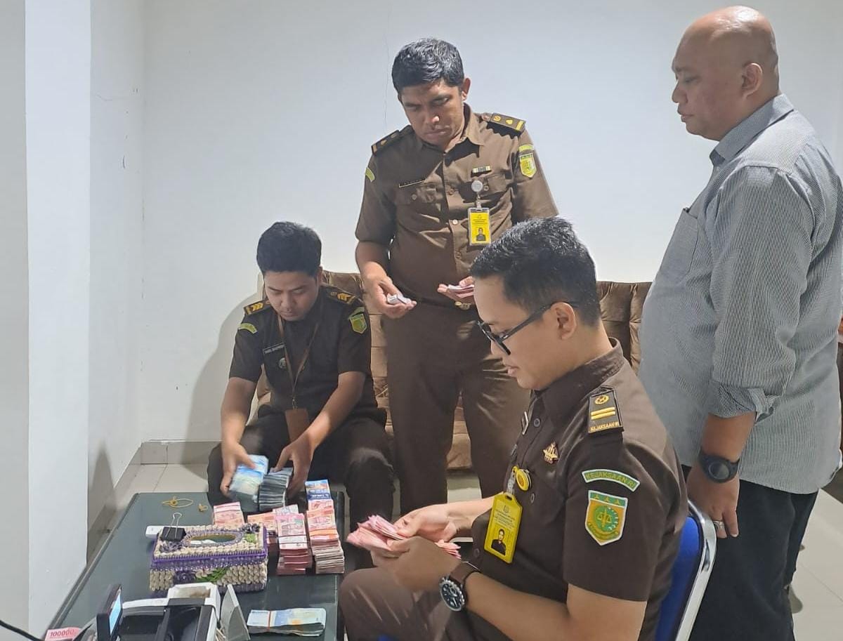 Tim jaksa Kejari Karanganyar menghitung uang yang diserahkan tersangka gratifikasi dalam kasus korupsi BUMDes Berjo. (Rudi Hartono/Radar Solo)
