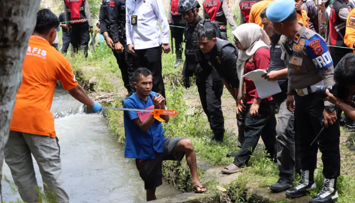 Indra Septriaman melakukan adegan saat rekontruksi kasus pembunuhan dan rudapaksa gadis penjual gorengan Nia Kurnia Sari di Padang Pariaman, Senin (7/10).