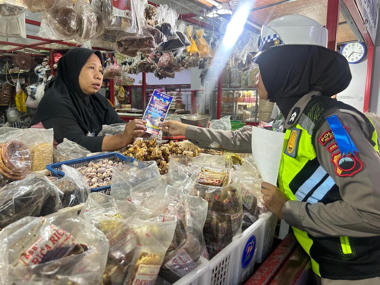 Personel Satlantas Polres Klaten bagikan selebaran imbauan tertib berlalu lintas ke pedagang Pasar Gedhe Klaten, Selasa (15/10/2024). (Dokumentasi Polres Klaten)