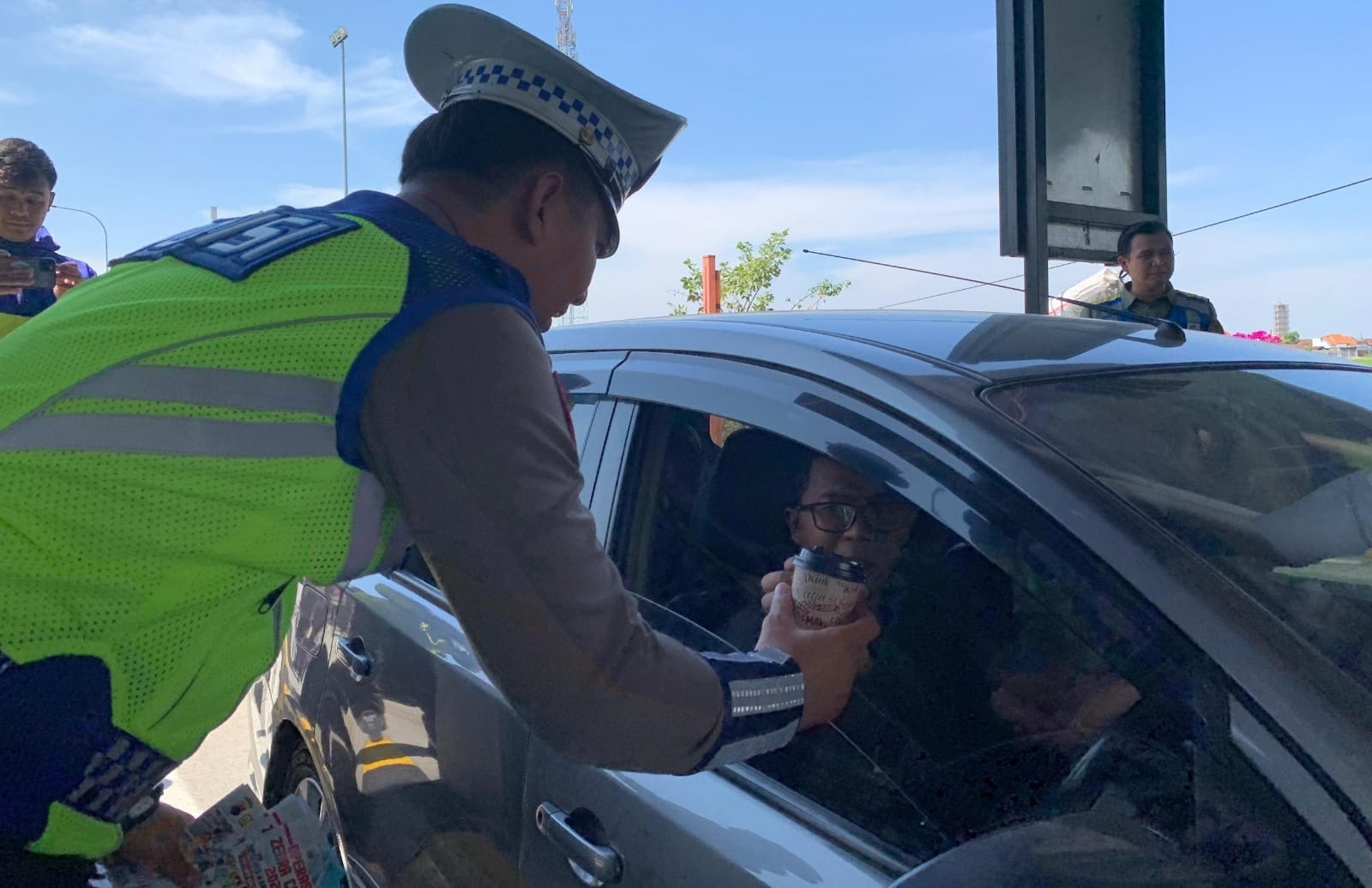 Personel Satlantas Polres Karanganyar membagikan kopi gratis ke pengemudi di jalan Tol Solo-Ngawi, Kamis (17/10/2024). (Rudi Hartono/Radar Solo)