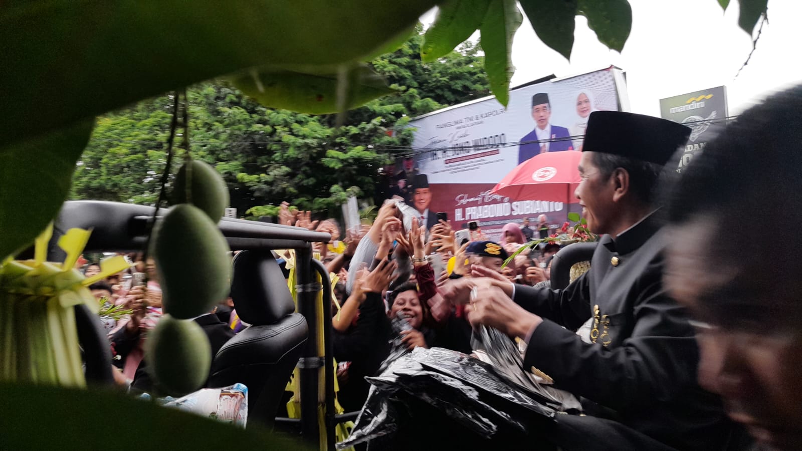 Presiden ke-7 RI Joko Widodo membagikan kaos kepada masyarakat yang menunggunya sejak siang di kawasan Lanud Adi Soemarmo, Boyolali, Minggu (20/10/2024).