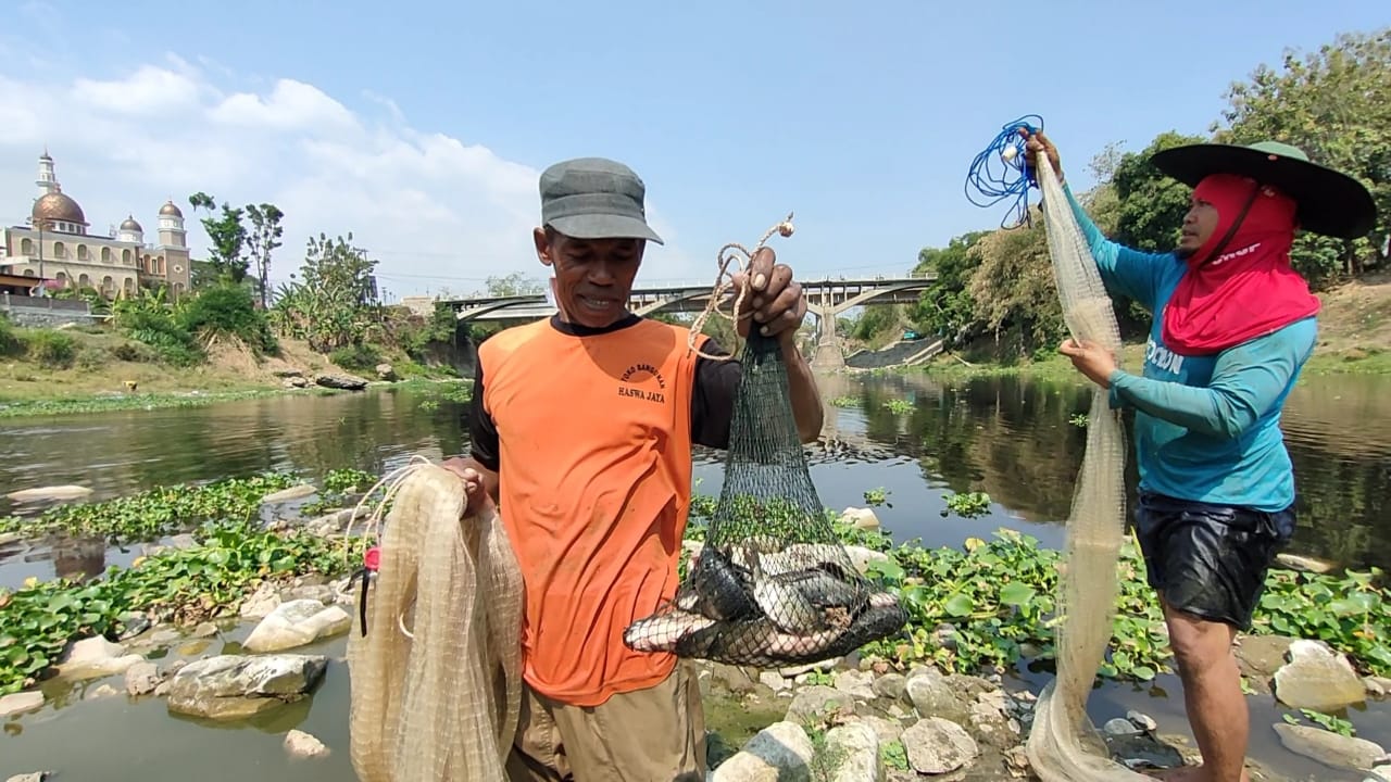 Warga menunjukkan hasil tangkapan ikan di Sungai Bengawan Solo wilayah Kabupaten Sragen. (Ahmad Khairudin/Radar Solo)