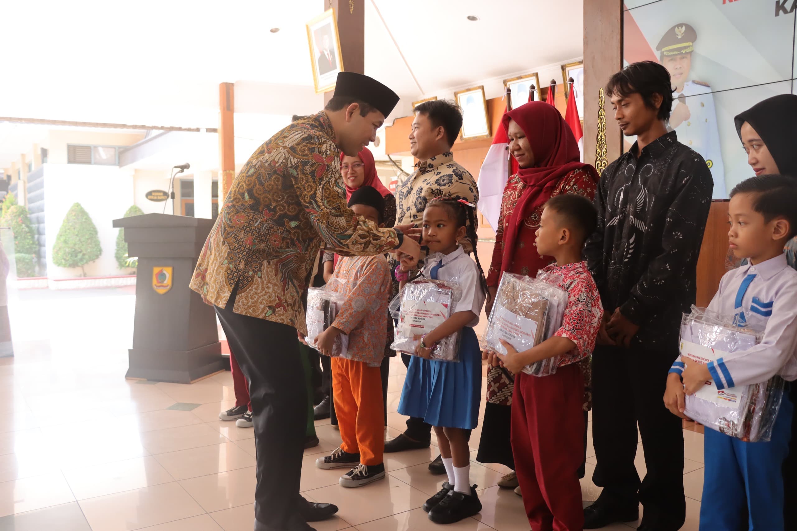 Bupati Wonogiri Joko Sutopo menyerahkan seragam gratis secara simbolis kepada perwakilan siswa di pendapa Rumah Dinas Bupati Wonogiri Jumat (1/11/2024).