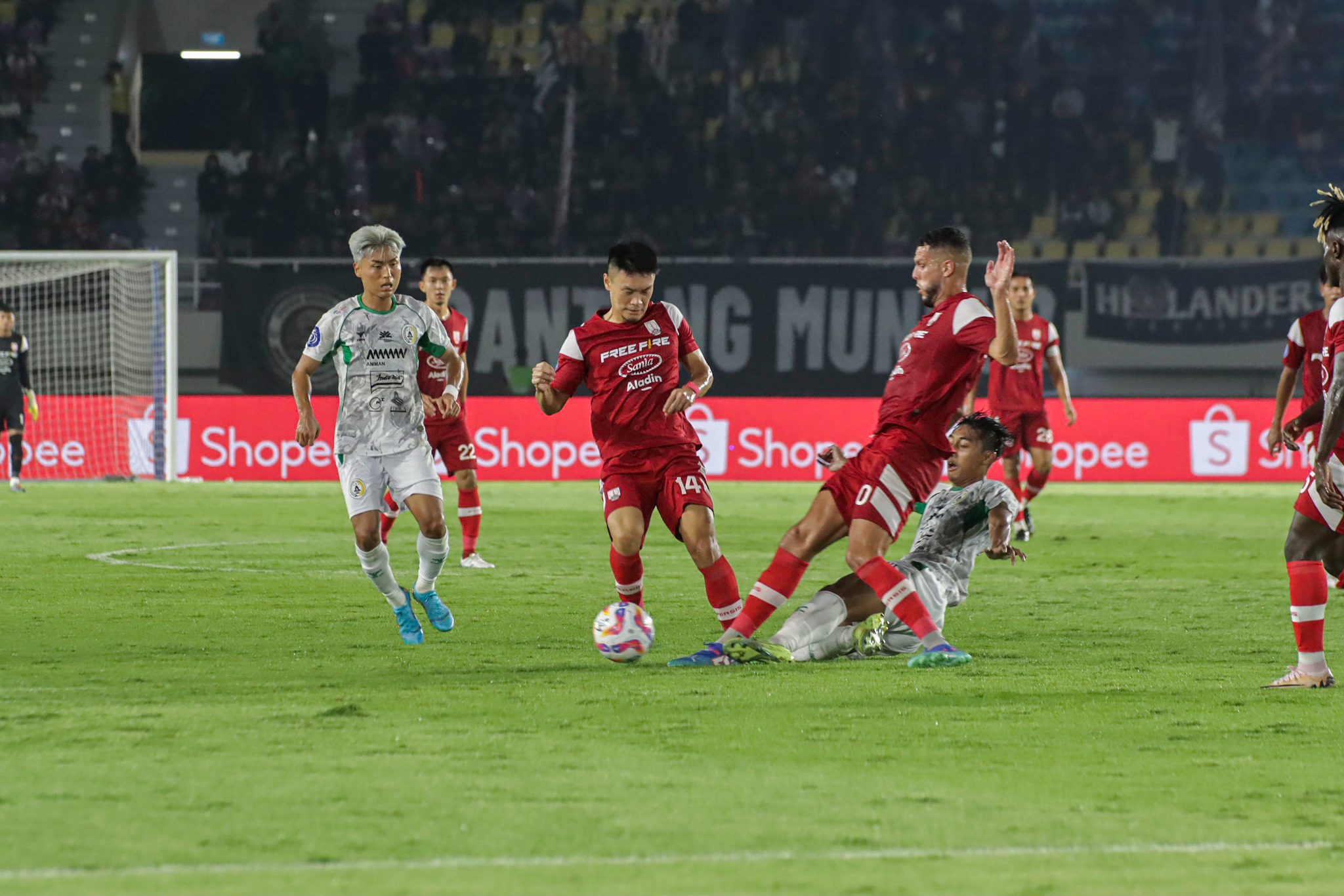 Dua pemain Persis Solo Sho Yamamoto dan Karim Rossi dijegal pemain PSS Sleman di Stadion Manahan, Minggu (3/11).