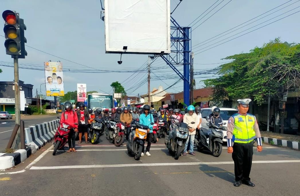 Pengendara bermotor mengheningkan cipta memperingati Hari Pahlawan di simpang empat Papahan, Minggu (10/11/2024). (Rudi Hartono/Radar Solo)