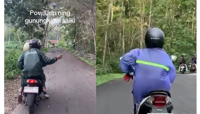 Tangkapan layar pengendara motor kenakan jas hujan dan membawa ranting untuk menghalau ulat jati.