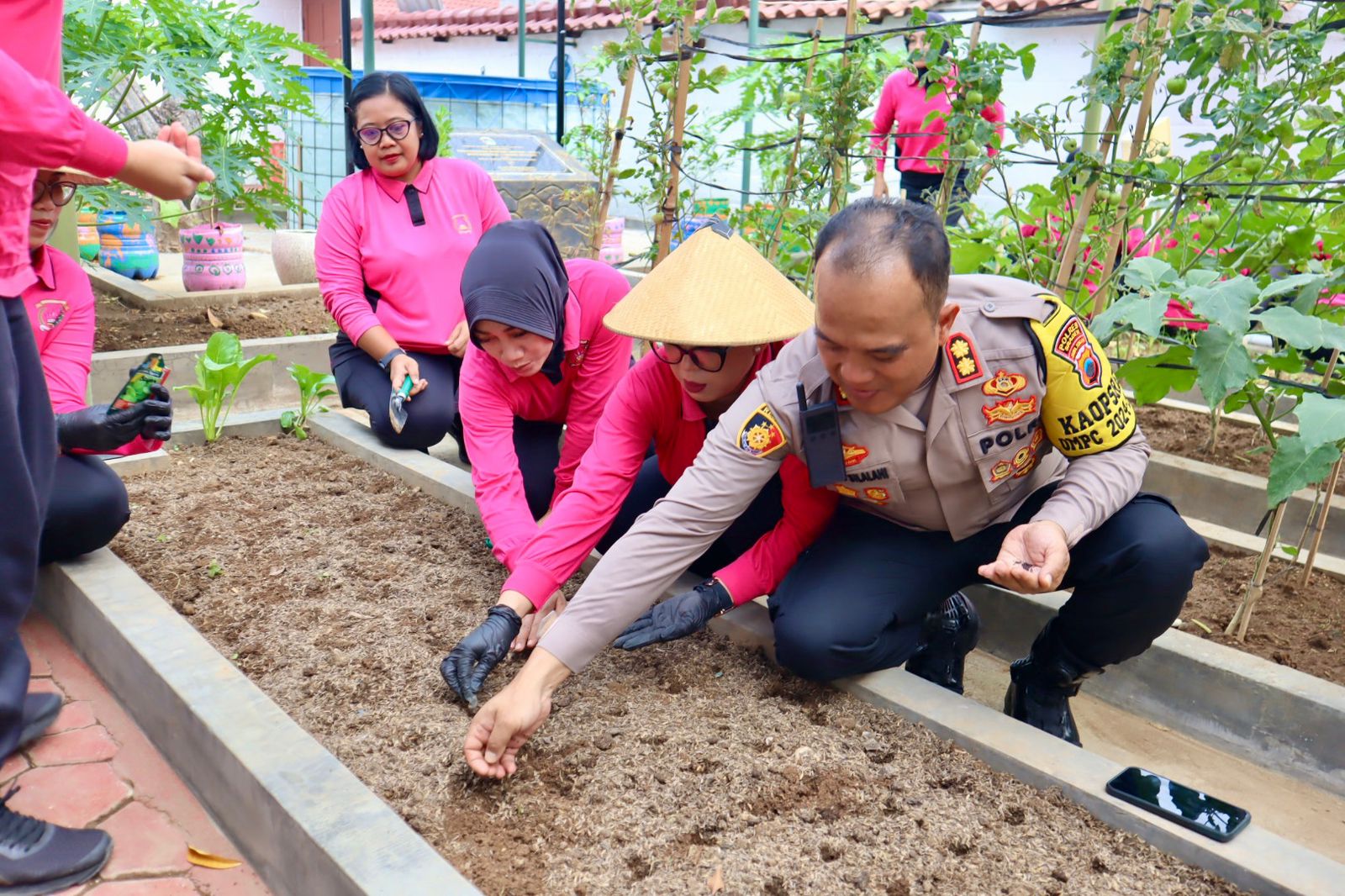 Kapolres Sragen AKBP Petrus Parningotan Silalahi bersama Ketua Bhayangkari Via Petrus menanam bibit sayur untuk dukung swasembada pangan nasional. (Ahmad Khairudin/Radar Solo)