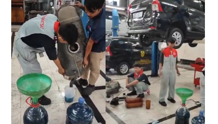 Tangkapan layar pegawai bengkel memperbaiki mobil yang rusak karena disebut-sebut isi bahan bakar Pertamax.
