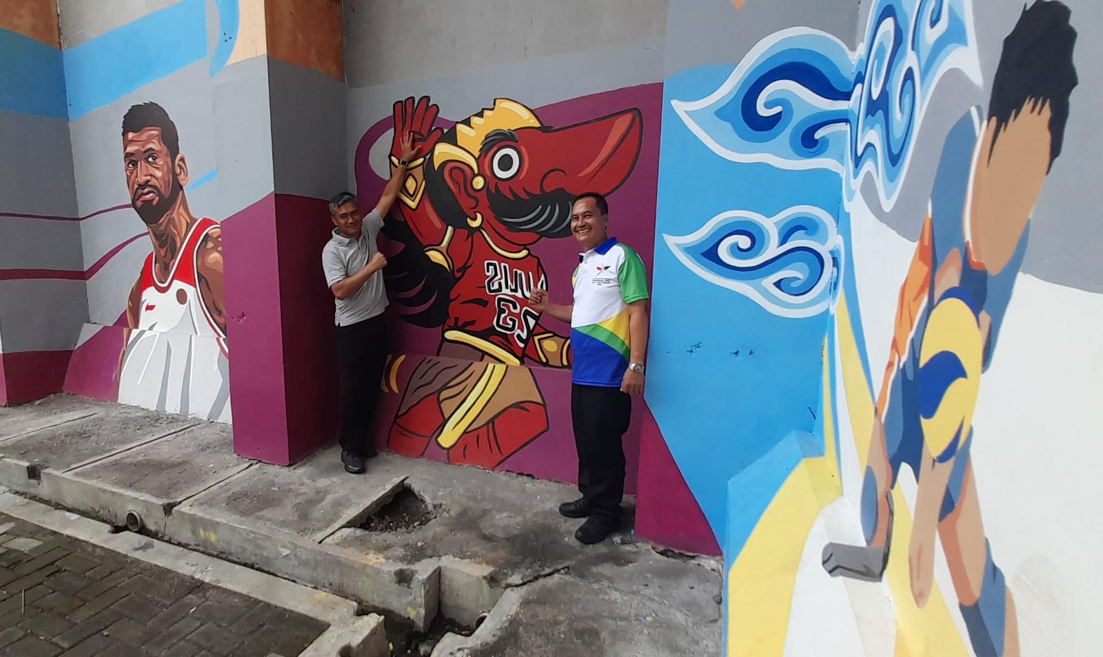 Pj Bupati Karanganyar Timotius Suryadi (kiri) bersama Kepala Disparpora Karanganyar Hari Purnomo berfoto di antara mural GOR Raden Mas Said. (Rudi Hartono/Radar Solo)