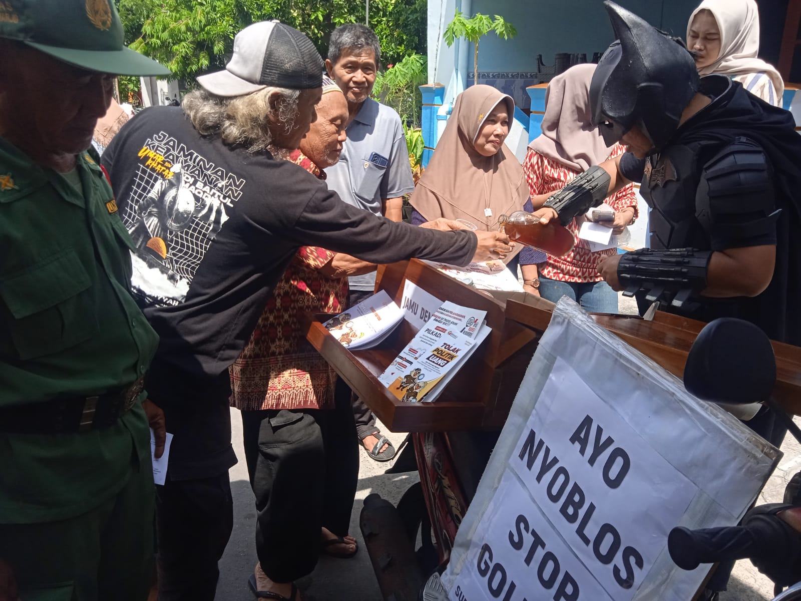 Agus Widanarko, relawan demokrasi dengan berkostum Batman menggugah semangat warga untuk segera nyoblos Pilkada Serentak 2024. Dia juga membagikan minuman jamu gratis, Rabu (27/11/2024).