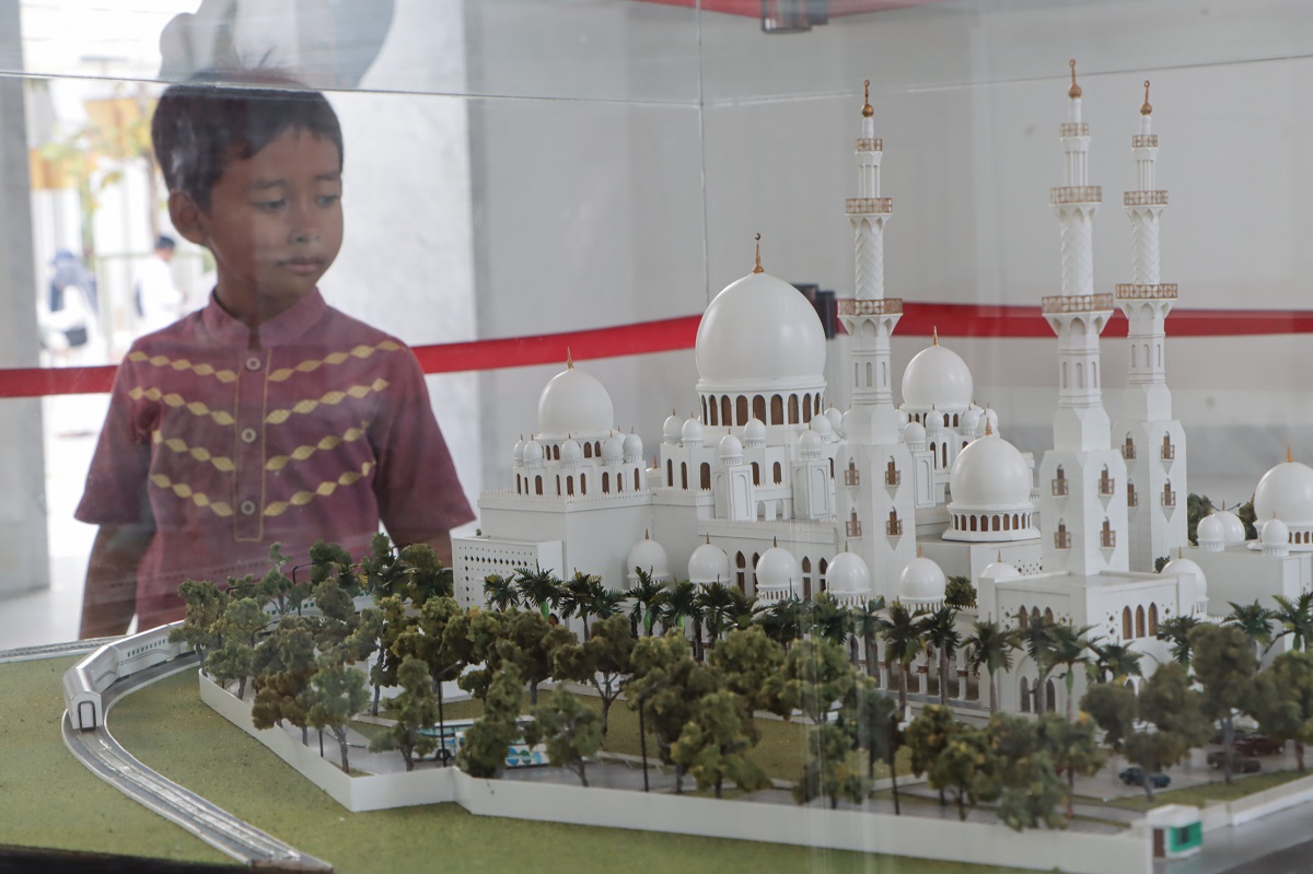 Seorang anak mengamati miniatur Masjid Raya Sheikh Zayed.