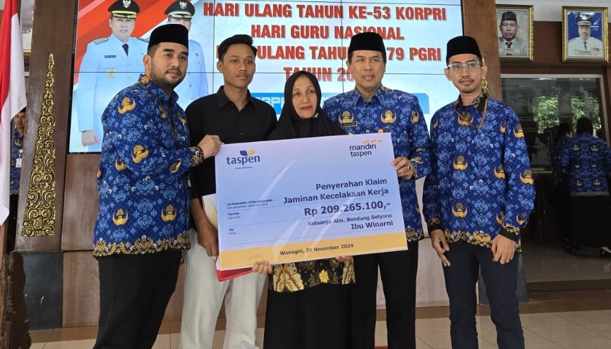Penyerahan JKK Jaminan Kecelakaan Kerja. Dari kiri BM TASPEN M.Harry Saputra, keluarga Alm. Bendung Setyono, Bupati Wonogiri Joko Sutopo, dan BM Bank Mandiri Taspen KCP Wonogiri Dandy.