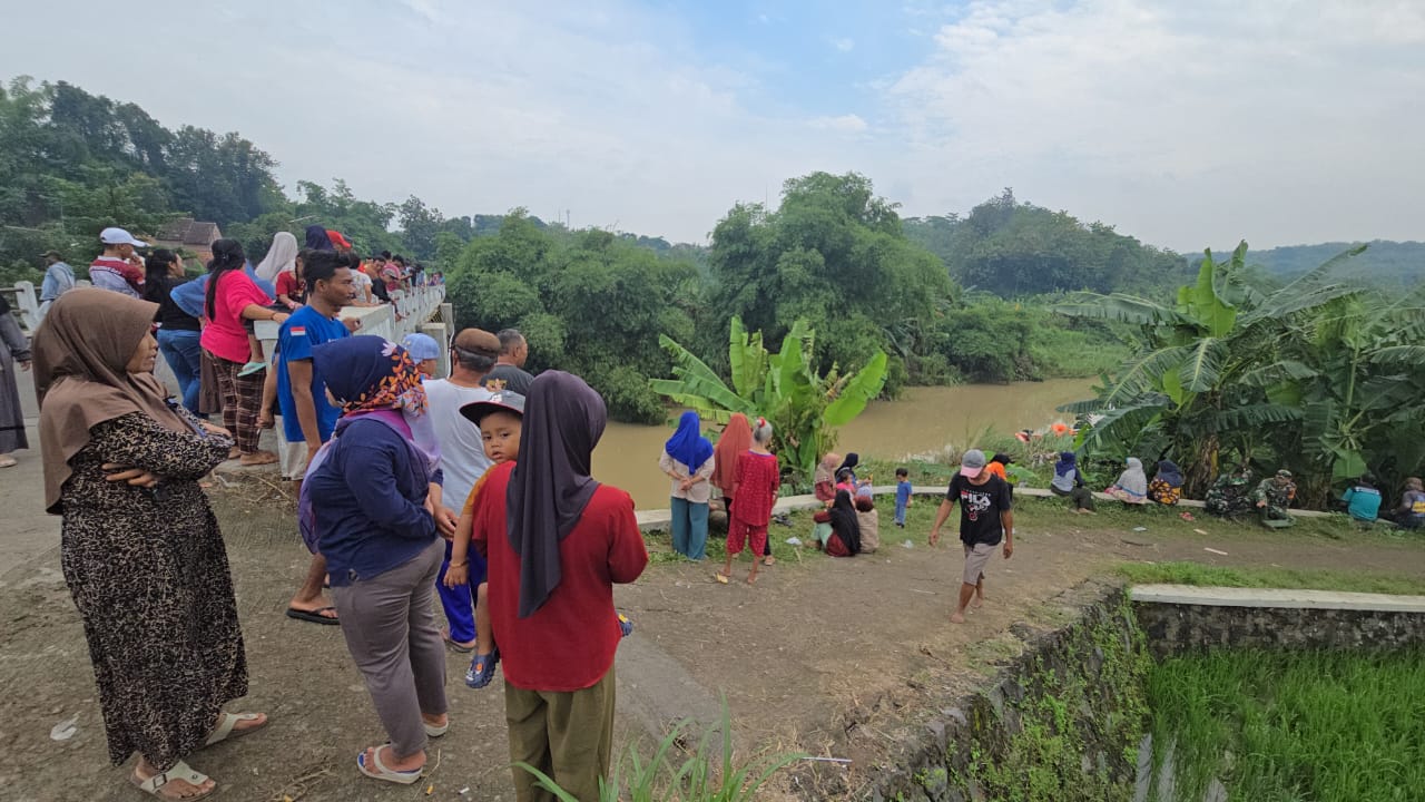 Warga melihat proses evakuasi pemuda di Sungai Cemoro, Kalijambe, Sragen. (Ahmad Khairudin/Radar Solo)