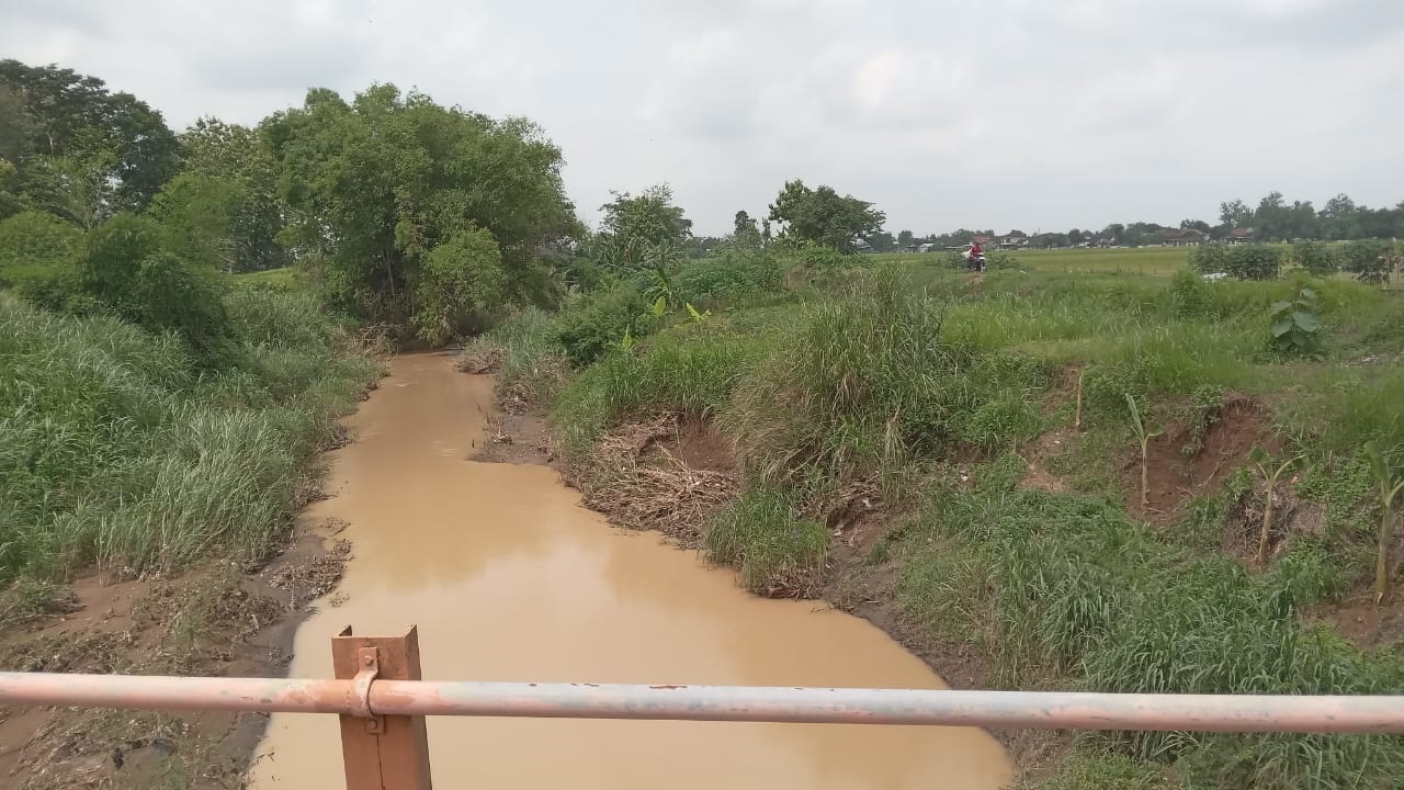 Warga melintas di tanggul Kali Jelantah di Kecamatan Nguter, Kabupaten Sukoharjo. (Iwan Kawul/Radar Solo)