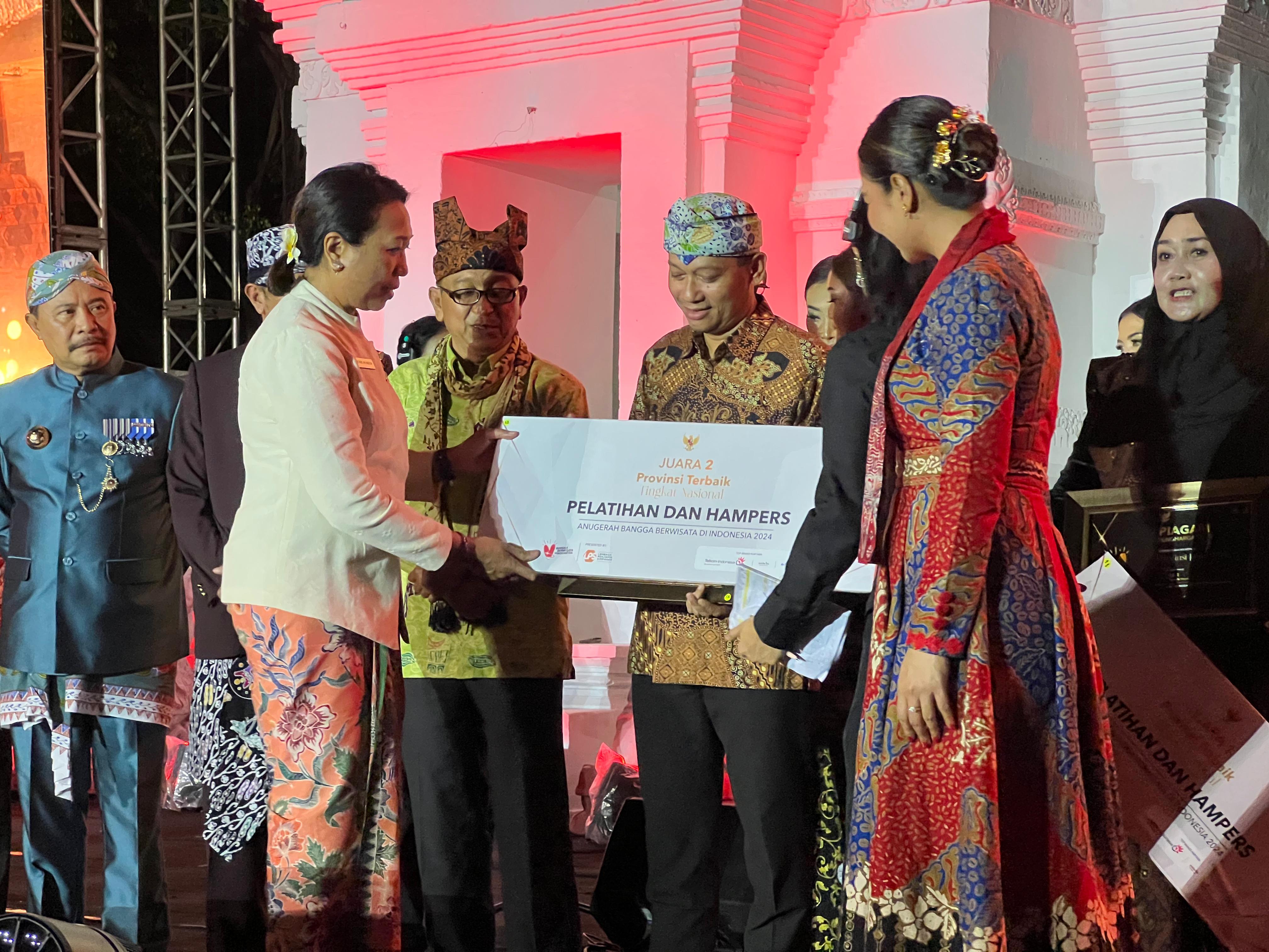 Wakil Menteri Pariwisata RI Ni Luh Puspa serahkan penghargaan kepada Kepala Disporapar Jateng Agung Hariyadi, di Taman Blambangan, Banyuwangi, Jumat ( 13/12/2024).