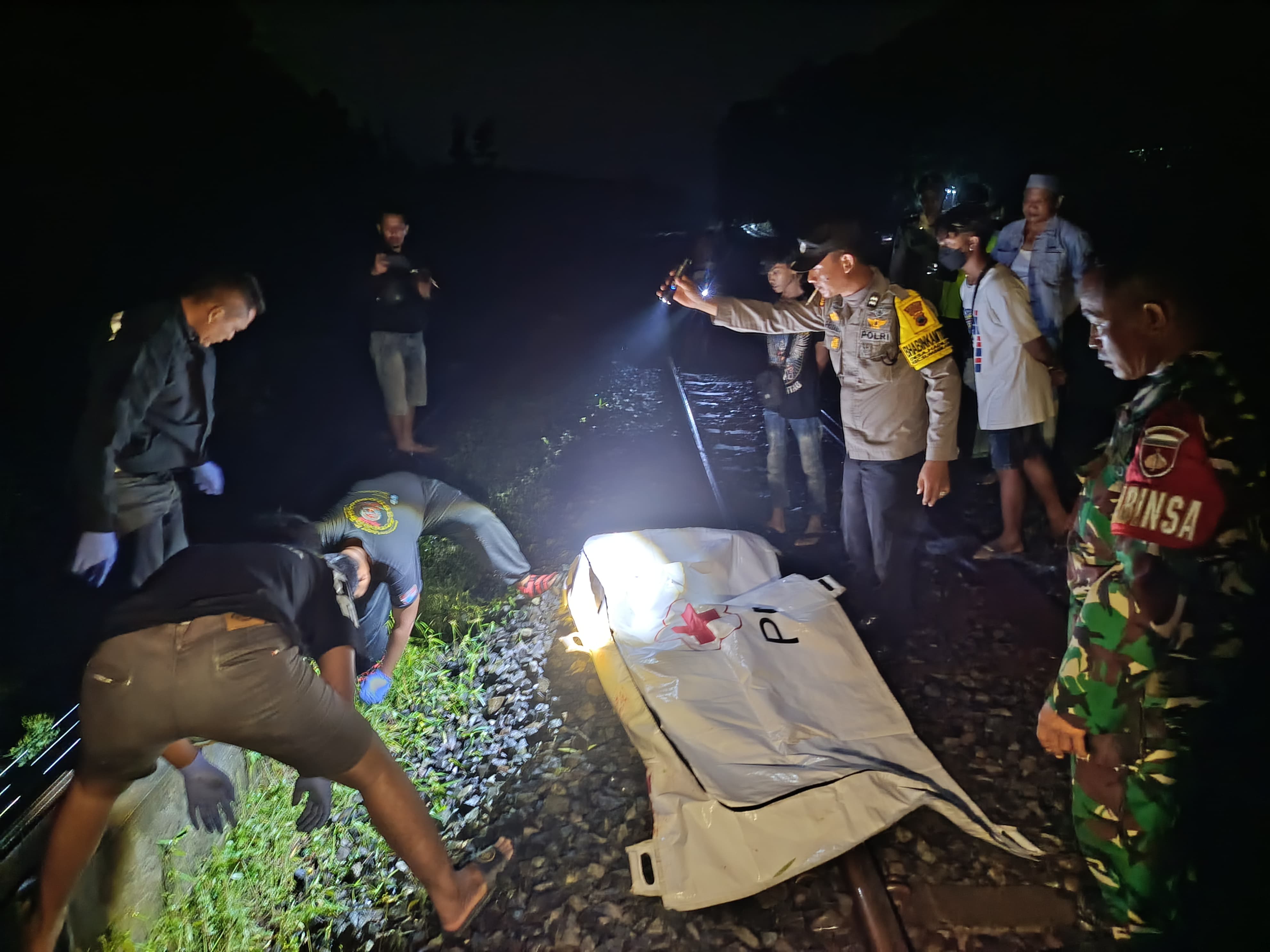 Polisi mengevakuasi jasad laki-laki tanpa identitas yang tertabrak KA di jalur Semarang-Solo, Kecamatan Sumberlawang, Sragen pada Minggu (15/12/2024) malam. (Ahmad Khairudin/Radar Solo)