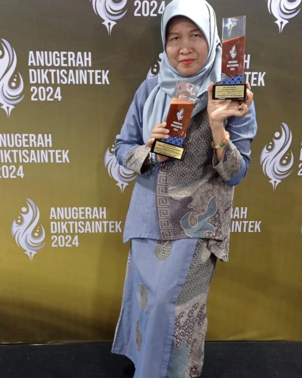 Dekan FSP ISI Surakarta Tatik Harpawati tunjukkan trofi penghargaan Anugerah Diksaintek 2024.